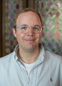 a man wearing glasses and a striped shirt
